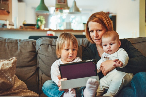 Mom sitting on floor playing with a toddler, both laughing