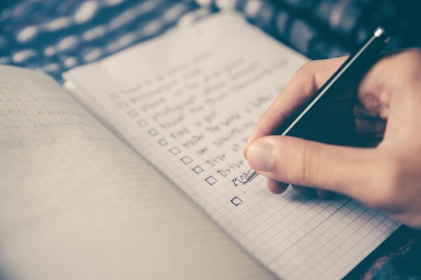 Woman smiling at her phone with a notepad nearby